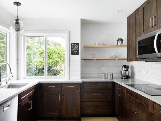 Dark brown kitchen cabinets set against white walls and white backsplash