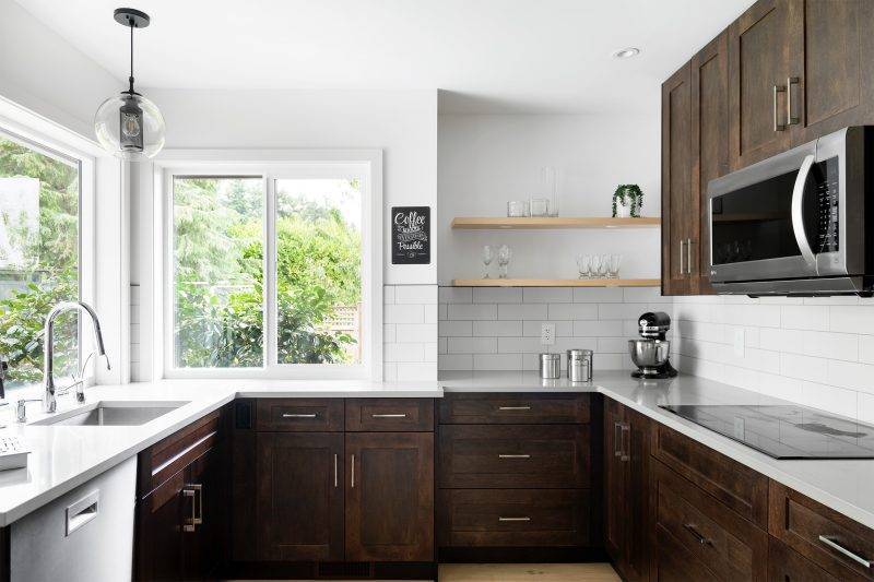 Dark brown kitchen cabinets set against white walls and white backsplash