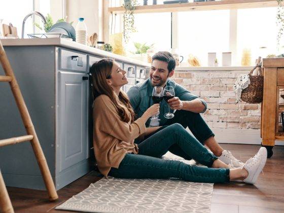 Couple drinking red wine in kitchen