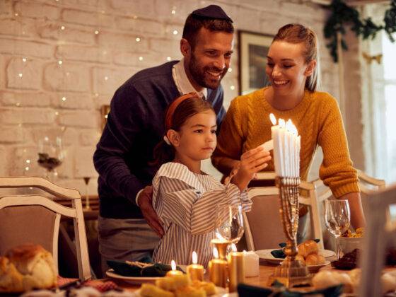 Child lighting menorah for Hanukkah.