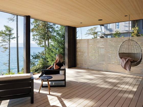 The private patio positioned off the primary ensuite is covered to allow for rainy days, the hanging chair an invitation to gaze at the ocean.